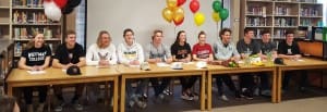 Summit student athletes gather to all sign together. 